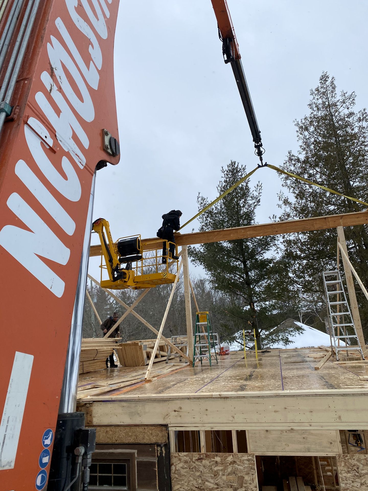 Nicholson crane setting a beam during framing