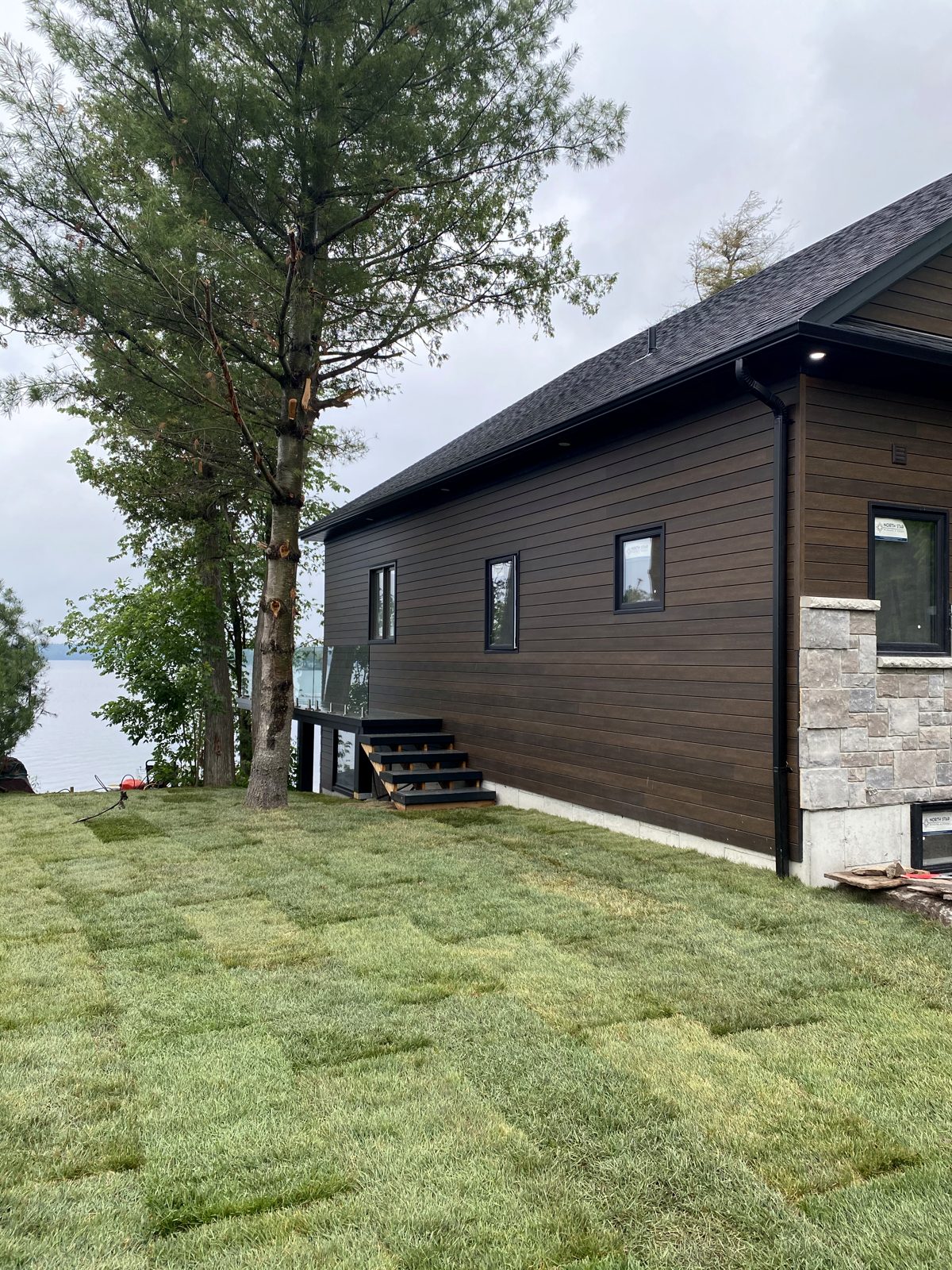 Dark-clad lakeside elevation with fresh sod