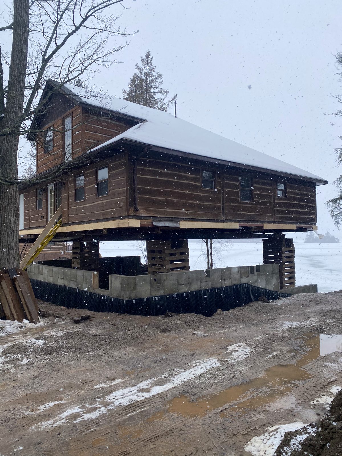Old cottage lifted on cribbing over a new foundation