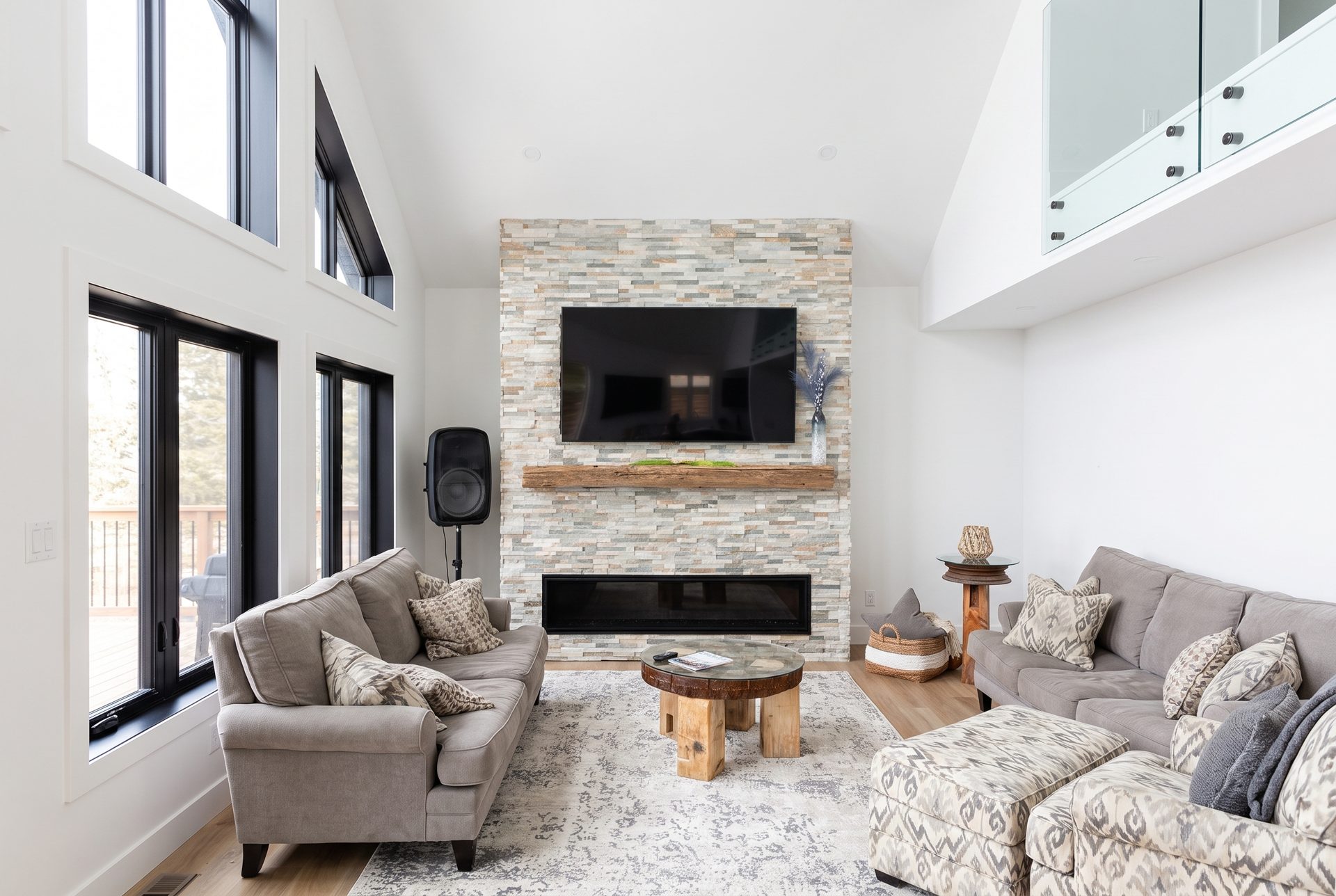 Living room — stacked-stone fireplace, wall of windows